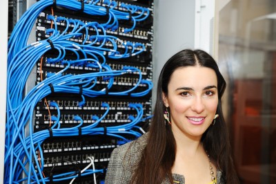 A woman standing next to a server rack